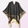 Detail of vintage golden jacquard patterns and cream fringe on a black poncho cloak - Pullover Poncho Origin Black Coffee
