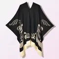 Detalle de un poncho de punto negro con motivos jacquard blancos y flecos largos - Jersey Pájaro Colorido Negro