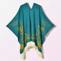 Detailed knit texture of a dark teal poncho with yellow patterns and white fringe trim - Pullover Colorful Bird Blue