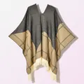 Detail of knit poncho featuring color-block patterns and cream tassel fringe trim - Pullover Five Star Plaid Black Beige