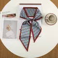 Detailopname van zijden twilly met geometrisch patroon gestrikt op een witte tafel - Rood Blauw Contrast Geometrische H (8)