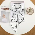 Elegante witte zijdeachtige smalle sjaal met zwarte stippen en puntige uiteinden op tafel - Black White Classic Polka Dot (10)