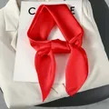 Close-up of knotted red silk scarf with elegant sheen on cream-colored blazer - One Size / True Red