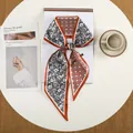 Detailopname van een elegante twilly sjaal met bloemenprint en geometrische sterren - Karame Oranje Geometrische Ster (39)