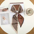 Detail van geometrische zijden sjaal in oranje en bruin op een minimalistische tafel - Wijnrood Grid Geometrisch (33)