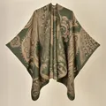 Close-up of olive green and beige paisley pattern on thick knit winter poncho shawl - Paisley Green