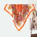 Elegante sciarpa in seta a fiori con bordo arancione su appendino da esposizione - Bouquet Floreale Arancione