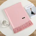 Soft pink cashmere-style winter shawl with fringe tassels on a minimalist table - Baby Pink