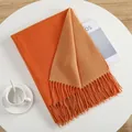 Minimalist double-sided orange cashmere-like scarf with long fringe on a white table - Bright Orange