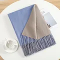 Close-up of sky blue and khaki cashmere-like scarf with fringe details on a table - Sky Blue Grey