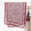 Dettaglio di una sciarpa boho in cotone e lino appesa con accessori per lo stile di vita - Viola