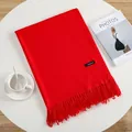 Vibrant red cashmere scarf with fringe details laid on a white surface for autumn - Red