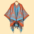Detailed view of the paisley jacquard pattern and black fringe on this orange shawl - Orange