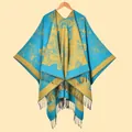 Detail of vintage floral pattern and black tassels on blue yellow winter poncho - Blue