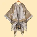 Detailed view of the khaki knitted shawl featuring large white floral jacquard and black tassels - Khaki