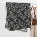 Elegant black and beige paisley print long scarf for women on a white hanger - Black