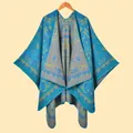 Detail view of ethnic blue poncho showing intricate paisley patterns and thick knit texture - Paisley Vine Lake Blue
