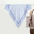 Detail of blue polka dot silk scarf draped elegantly next to a brown leather bag - Dark Blue Polka Dot