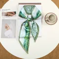 Elegante zijden sjaal met groene olieverfprint op een stijlvol lifestyle-boek op tafel - Grasgroen Olieverf Print (54)