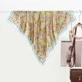 Detail of khakhi silk scarf featuring daisy floral patterns and blue contrast hem - 70x70cm / Daisy