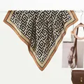 Close-up of a satin scarf with black and caramel geometric maze patterns and Greek key borders - 70x70cm / Geometric Maze