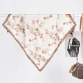 Detailed view of beige silk scarf with orange leaf prints and dark brown hem edges - Watercolor Daisy Coffee / 70x70cm