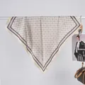 Detail eines eleganten Seidenschals mit geometrischen Mustern an einer Metallstange - Bandana / Weiß Geometrisch