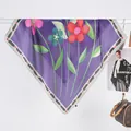 Gros plan d'un carré de soie violet léger avec des motifs floraux roses et bleus - Violet