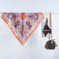 Détail d'un foulard carré en satin à motif paisley avec des bordures orange vif - Cachemire Coloré