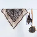 Détail d'un foulard carré en satin rétro avec des motifs floraux marron vintage - Carré Paisley