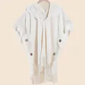 Detail of bohemian cream knit hooded shawl featuring decorative tassels and wooden buttons - Off White