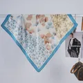 Dettaglio di un foulard in seta con motivi floreali blu e beige e bordo a contrasto - Blu Ginkgo Floreale