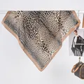 Detail showing the sheer texture and leopard print of the brown satin square scarf - Snake Coffee