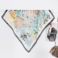 Detail view of floral silk scarf featuring botanical prints and stylish black borders - 70x70cm / Black