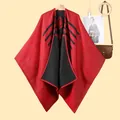 Dettaglio macro del poncho in maglia rosso e nero con motivi geometrici e trama spessa - Nero Rosso (Riga Arrotolata Rombo)