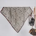 Close-up of leopard print satin scarf draped elegantly with luxury fashion accessories - 70x70cm / Black Coffee
