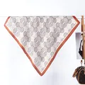 Dettaglio della sciarpa effetto seta con motivi geometrici e bordo marrone - Stile ad Anello / Arancione