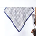 Dettaglio foulard in seta con motivi a onde blu e bordo solido in primo piano - Stile ad Anello / Blu navy