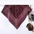 Detailaufnahme eines dunkelroten Paisley-Seidentuchs mit weißen Punkten am Kleiderbügel - Paisley Gepunktet Gitter / Burgunderrot