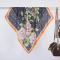 Satin silk scarf with retro floral print and orange borders draped on a white hanger - 70x70 / Navy Blue