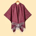 Detail of burgundy knit shawl featuring thick texture and contrasting white fringe tassels - Marled Wine Red