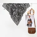 Exotic retro paisley flower silk scarf in black and white hanging on a white rack - Black
