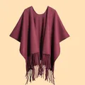 Detailed texture of thick burgundy winter poncho featuring soft fringe tassels on the hem - Burgundy