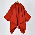 Detail of red knitted hooded poncho showing thick texture and fine stitching on the edges - Red