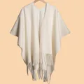 Detailed view of cream white fringed shawl featuring soft knit texture and long tassels - White