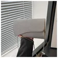 Close-up of the silver glitter texture and asymmetrical wave flap on the evening clutch bag - Silver