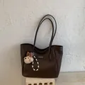 Dettaglio borsa shopper marrone con ciondolo a forma di orsetto ed etichetta del marchio - Caffè Con Pendente