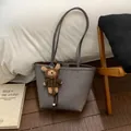 Détail du sac cabas gris texture litchi avec un pendentif ours en peluche marron - Gris Avec Pendentif