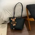 Détail d'un sac cabas en cuir noir texturé avec un joli pendentif ours en peluche marron - Noir Avec Pendentif
