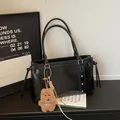 Black vintage tote bag with metal studs and a brown plush bear charm pendant - Black With Pendant